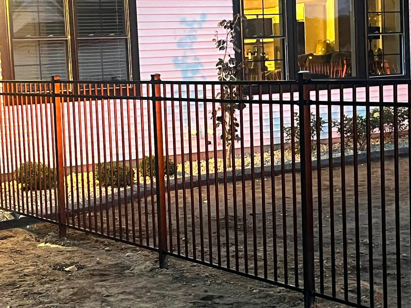 Black aluminum fence beside a home